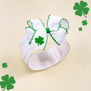 Macro detail of St. Patrick's Day baby headband with green shamrock pattern bow