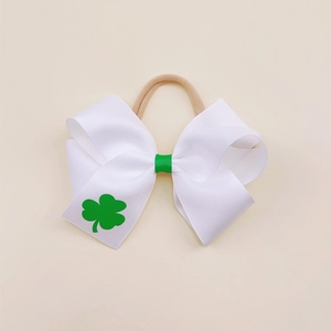 Close-up of white clover bow headband with green shamrock pattern and nylon band