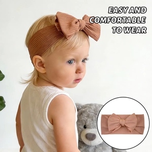 Macro detail of brown ribbed knit baby headband featuring a soft elastic bow design