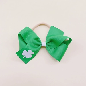 Macro detail of St. Patrick's Day green nylon headband with clover bow and texture