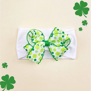 Detail of St. Patrick's Day baby headband with a large green shamrock print bow