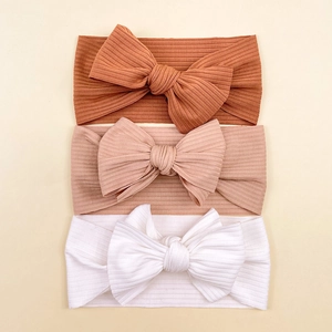 Three-pack of soft ribbed knit baby headbands with large bows in caramel and pink