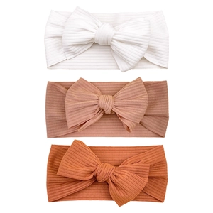 Three-piece set of ribbed knit baby headbands with large bows in white, pink, and orange