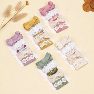 Détail de cinq barrettes à fleurs pour enfants avec nœuds en dentelle et broderie