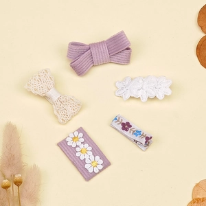Détail du lot de 5 barrettes à fleurs en tissu avec broderies et nœuds en velours côtelé