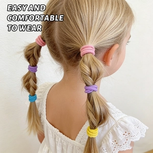 Détail d'élastiques à cheveux colorés portés en queue de cheval et tresse pour enfant