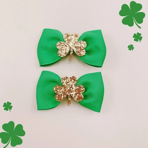 Dettaglio di fermagli a fiocco verdi con trifogli di paillettes dorate per San Patrizio