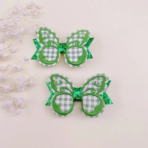Détail de pinces à cheveux papillon à carreaux verts avec des accents pailletés