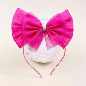 Détail du serre-tête nœud en maille rose rouge avec paillettes argentées sur céramique