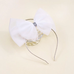 Détail d'un serre-tête en tulle blanc avec nœud papillon et paillettes argentées