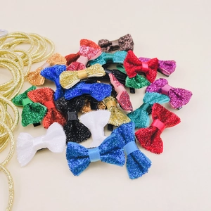 Dettaglio di fermagli per capelli a fiocco in velluto glitterato in vari colori vivaci