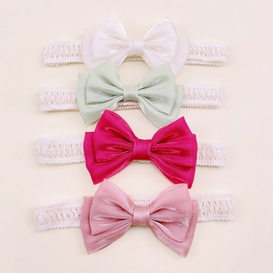 Close-up of four colors baby bow headbands in lace and satin for infants 0-3 years