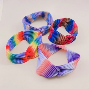 Detail of four yoga headbands with rainbow gradient and tie-dye patterns in twisted fabric