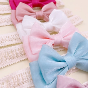 Detailed macro view showing delicate lace texture and satin bow of infant headbands