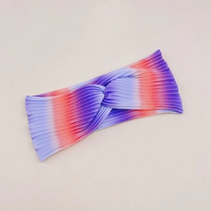 Detail of rainbow gradient ribbed fabric with cross-knot design on elastic headband