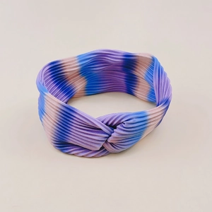 Detail of pleated fabric texture on a rainbow gradient twisted yoga headband