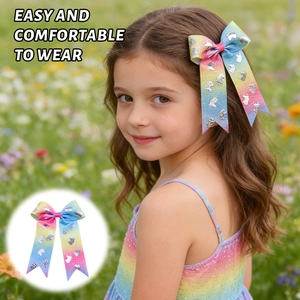 Outdoor shot showing girls' large rainbow gradient bow hair clip with silver unicorn detail