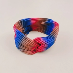 Detail of multi-color gradient pleated twisted headband with elastic fabric texture