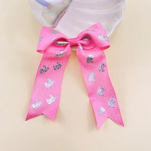 Detail of pink grosgrain ribbon bow with silver unicorn print and long streamers