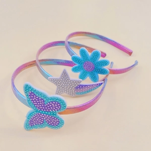 Detail view of three gradient children hairbands with star flower and butterfly shapes