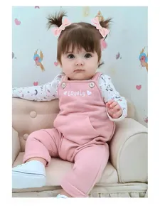 Baby girl wearing pink velvet bow hair tie sitting on a mini sofa in a warm setting