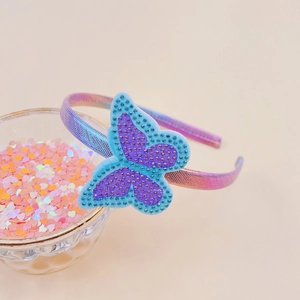 Close-up of sparkling rhinestone butterfly headband with a colorful gradient fabric band