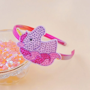 Detailed close-up of a rhinestone-studded unicorn headband for girls in gradient fabric