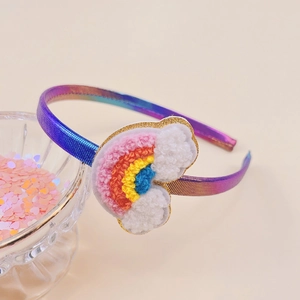 Close-up of rainbow fabric headband with chenille rainbow cloud patch and gold glitter