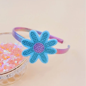 Detail of blue rhinestone flower headband with purple center and iridescent band