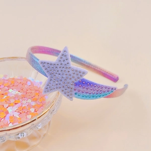 Close-up of a rhinestone shooting star headband for girls in pink and blue gradient fabric