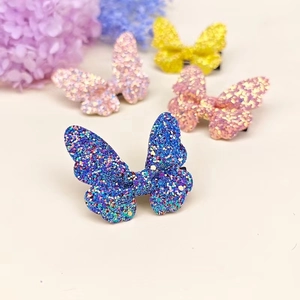 Close-up of glitter butterfly hair clips in blue, pink, peach, and yellow colors