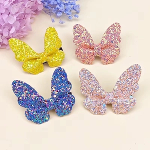 Set of four butterfly hair clips with glitter finish in yellow, purple, blue and gold colors