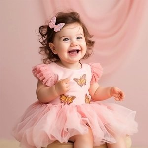 Pink glitter butterfly hair clip worn by a toddler model in a tutu dress