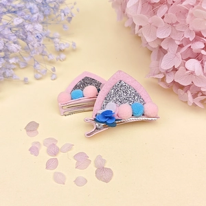Détail de pinces à cheveux oreilles de chat roses avec paillettes et pompons pour enfants