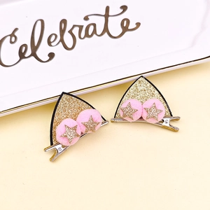 Détail de pinces à cheveux oreilles de chat à paillettes avec pompons roses et étoiles