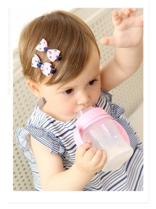 Toddler wearing pink polka dot grosgrain bow clips for side hair styling