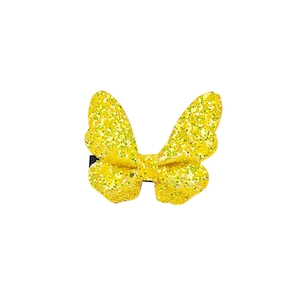 Detailed macro view of yellow glittery butterfly hair clip with shimmering texture