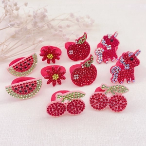 Detailed view of red rhinestone fruit hair ties including apple and cherry shapes
