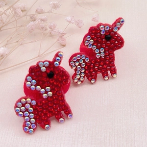 Close-up of red rhinestone unicorn accessories with sparkling crystals and fine details