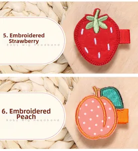Détail de barrettes brodées fraise et pêche sur des pinces à cheveux en tissu