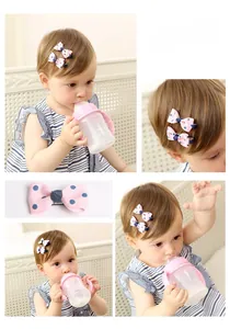 Detailed view of pink bow hair clip with blue polka dots on a young child's hair