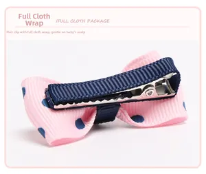 Detail of pink polka dot bow hair clip featuring safe full fabric wrapped metal base