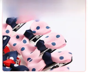 Close-up of handmade pink polka dot bow hair clips with silver metal alligator clips