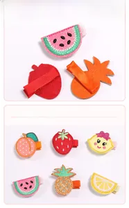 Détail de barrettes à fruits brodés pour bébés avec motifs de citron et de pastèque