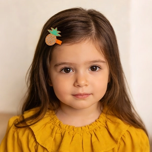 Détail de la pince à cheveux enfant motif ananas avec paillettes et ruban orange doux