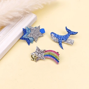 Détail de barrettes à paillettes avec étoiles bleues, baleine et motif arc-en-ciel