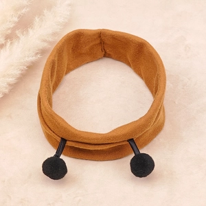 Detailed knit texture of caramel baby headband featuring cute black pompom antennae