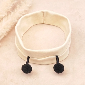 Detailed close-up of cream ribbed cotton baby headband with black plush bee antennae