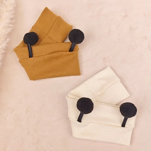 Detail view of ginger and cream knitted baby headbands with cute plush balls