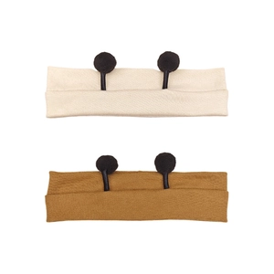 Detail view of two-pack knit baby headbands in beige and caramel with cute antenna poms